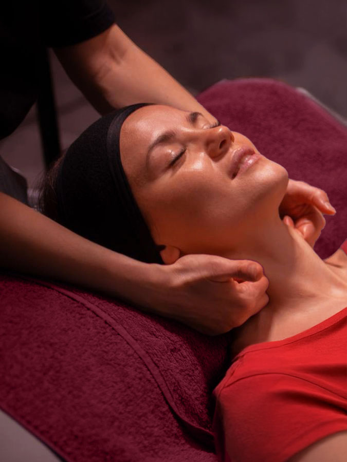 une ostéothérapeuthe offre un soin à sa patiente allongée